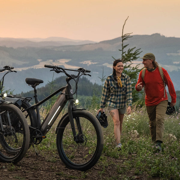 Two people walking towards their bikes on an autumn day.